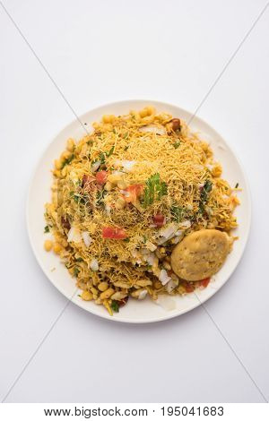 Bhel Puri - Popular Mumbai street food served with coriander and tamarind chutney on white background, selective focus