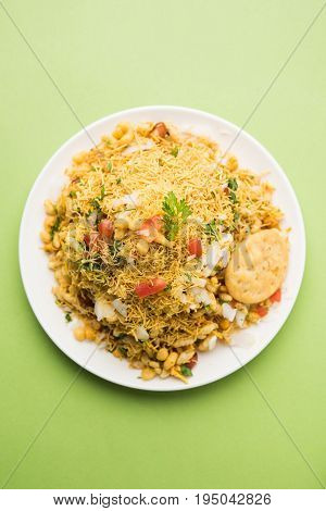 Bhel Puri - Popular Mumbai street food served with coriander and tamarind chutney on white background, selective focus
