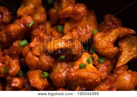 Gobi Manchurian dry - Popular street food of India made of cauliflower florets in a frying pan, selective focus