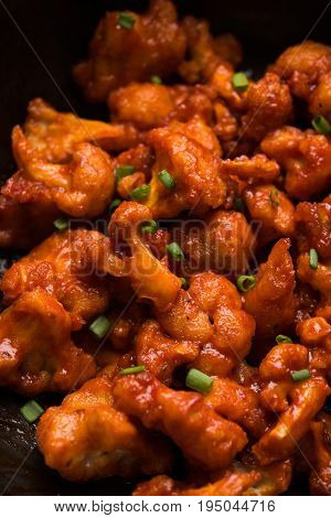 Gobi Manchurian dry - Popular street food of India made of cauliflower florets in a frying pan, selective focus