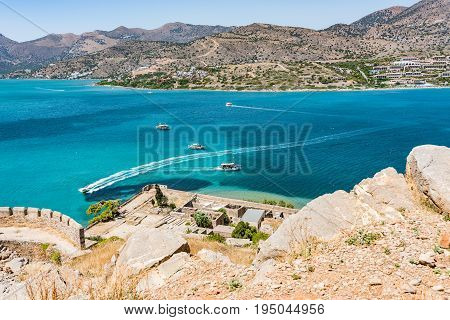 Top Of Spinalonga Fortress. View To Blue Aegian Sea With Boats, And Mirabello Coast.