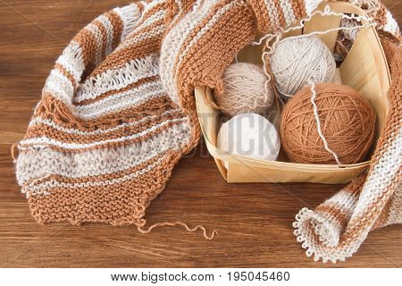Balls of wool and knitting on the wooden background
