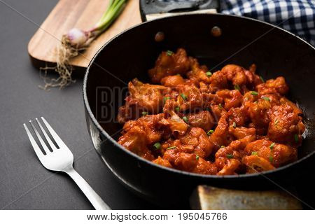 Gobi Manchurian dry - Popular street food of India made of cauliflower florets in a frying pan, selective focus