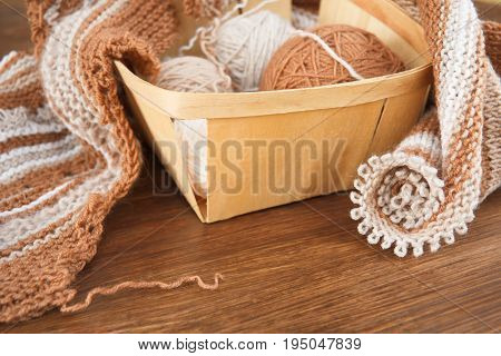 Balls of wool and knitting on the wooden background