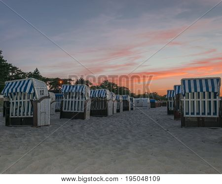baskets on the beach at sunset with red clouds and blue sky