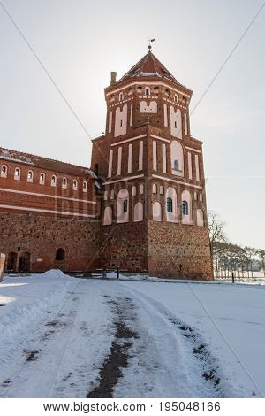 Mir Castle in Minsk region is ancient heritage of Belarus. UNESCO World Heritage. Winter scene with snow and tower backlit