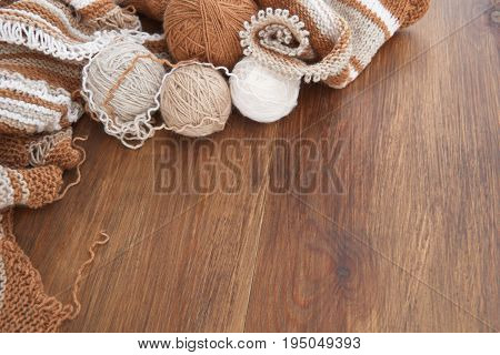 Balls of wool and knitting on the wooden background