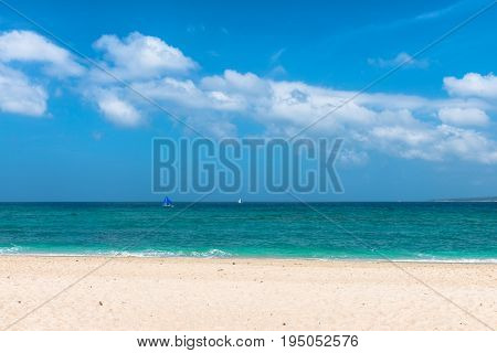 BORACAY WESTERN VISAYAS PHILIPPINES - JANUARY 14 2015: Wide angle view of sunny day in Puka Beach. Two boats are sailing in a mixed green and blue water.