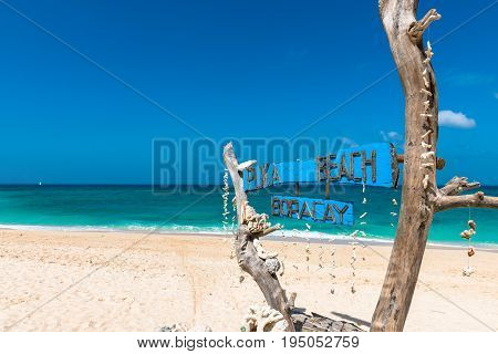 BORACAY WESTERN VISAYAS PHILIPPINES - JANUARY 14 2015: Wooden board written Puka Beach the name of the beautiful beach of the island of Boracay. Blue sky in a summer season.