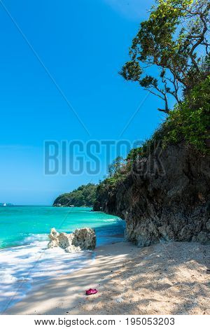 BORACAY WESTERN VISAYAS PHILIPPINES - JANUARY 14 2015: Vertical picture of a pair of shoes in the beautiful Puka Beach.