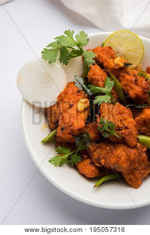Chicken 65 - spicy deep fried Bar appetizer or quick snack from India in a bowl or plate over white background, selective focus