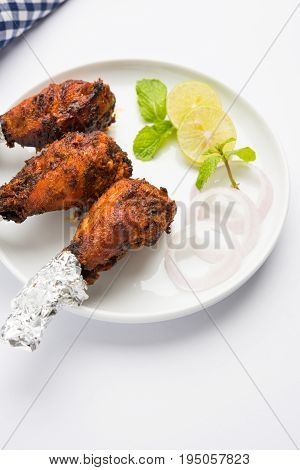 Chicken Tangri kabab or kebab - three Chicken leg pieces marinated with red sauce then grilled and served with salad. It can be served with green chutney