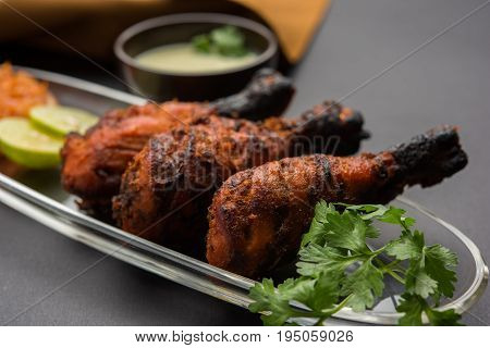 Chicken Tangri kabab or kebab - three Chicken leg pieces marinated with red sauce then grilled and served with salad. It can be served with green chutney