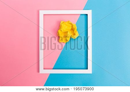 Crumpled paper ball with frame on a bright split tone background