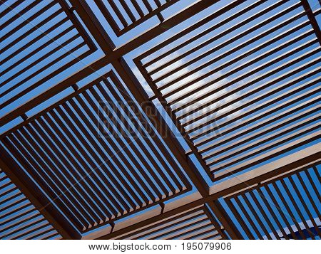 Modern design pergola arbor made wood and metal with clear blue summer sky background