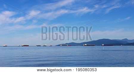 Ships in the roadstead. Peaceful sea with ships and mountain on horizon near city of Vancouver Canada.