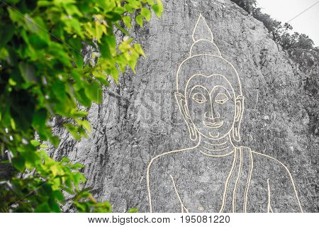 Golden Big Buddha on the mountain Khao Chi Chan Pattaya Thailand whit green leaf foreground