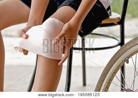 close up little girl touching knee with elastic bandage