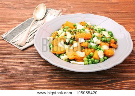 Warm salad with roasted pumpkin, peas and cheese brie. Low fat healthy eating concept.