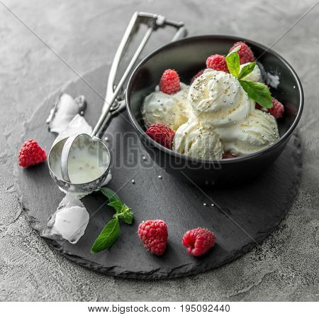 ice cream with raspberries served in black piala