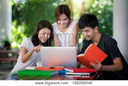 Asian student do report and home work togather at library in university