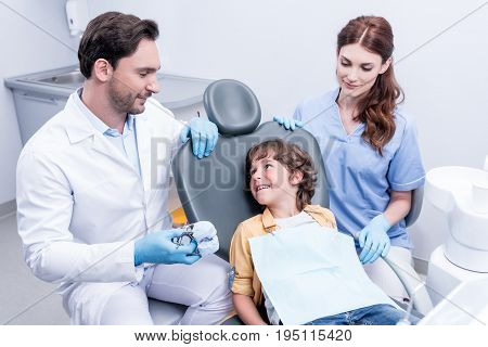 Dentists Preparing Little Boy For Examining Teeth At Dentist Office