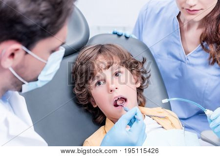 Dentists Examining Teeth Of Little Boy At Dentist Office