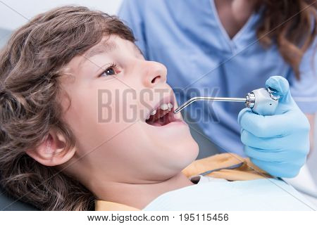 Close Up View Of Dentist Treating Teeth Of Little Boy In Dentist Office