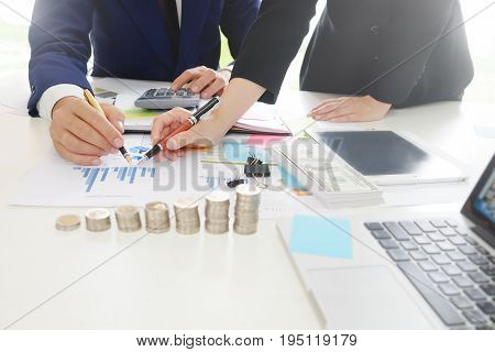 Business adviser analyzing financialFinancial planning Business man and Business woman talking to planner financial business report finance in paper on office accounting.