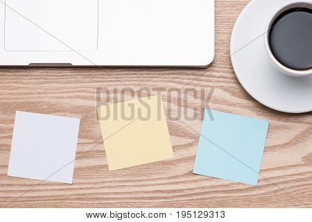 Laptop with colorful stickers on wooden table.
