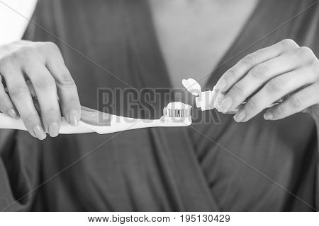 Closeup On Young Woman Squeezing Toothpaste On Toothbrush