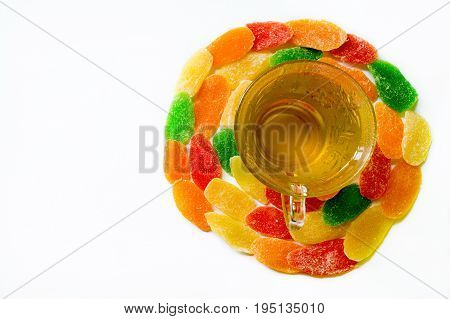 Glass Cup Of Green Tea Surrounded By Candied Pineapple On White Background. Copy Space