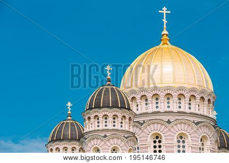 Riga, Latvia. Riga Nativity Of Christ Cathedral - Famous Church And Landmark. Close Up Of Golden Yellow Domes On Blue Sunny Sky Background At Summer Season