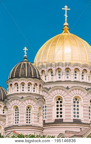 Riga, Latvia. Riga Nativity Of Christ Cathedral - Famous Church And Landmark. Close Up Of Golden Yellow Domes On Blue Sunny Sky Background At Summer Season