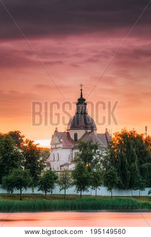 Nesvizh, Minsk Region, Belarus. Corpus Christi Church And Castle Pond Lake At Summer Sunset Evening Or Sunrise Morning. Famous Landmark In Nyasvizh.