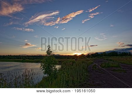 Beautiful shades and clouds in the sky are reflected in the river surface at the time of sunset.
