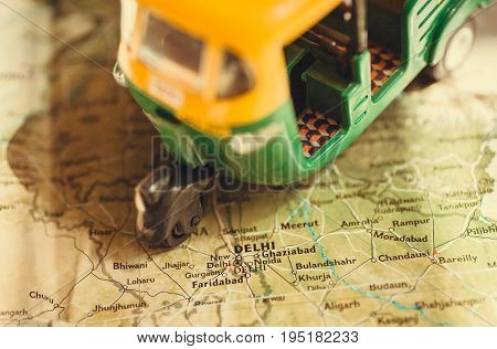 Toy model of auto rickshaw vehicle driving on India map with many cities and the capital in Delhi
