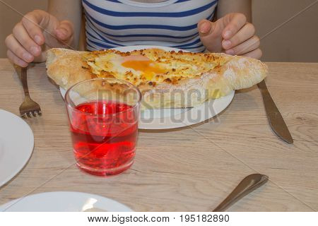 Adjarian khachapuri close-up. This traditional georgian dish contains brinsen cheese butter and row egg. Delicious homemade khachapuri in Adjarian