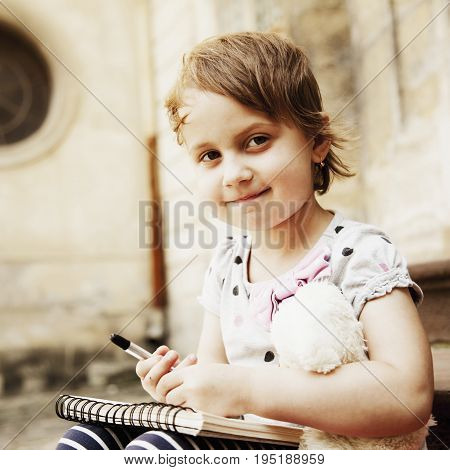 Beautiful child girl is preparing for exams (prescool education knowledge success responsibility concept)