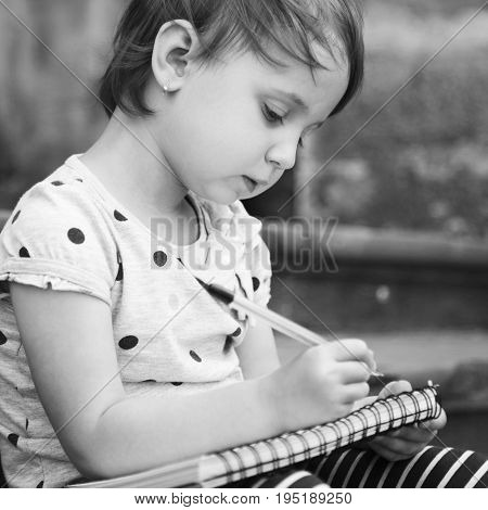 Beautiful child girl is preparing for exams (prescool education knowledge success responsibility concept)
