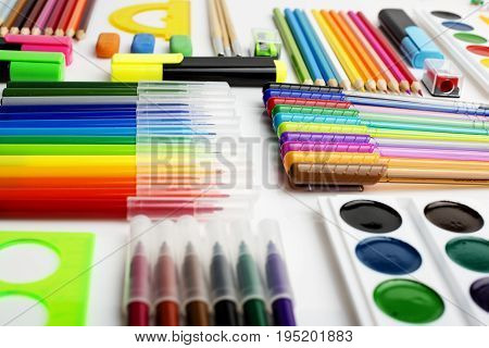 A lot of stationery on the white surface, diagonal rows, background