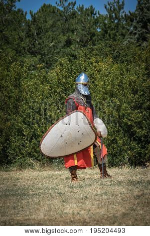 Medieval knight ready for battle, reenactment with costumed characters and medieval armor with chainmail, helmet swords and shields. Medieval demonstration and recreation