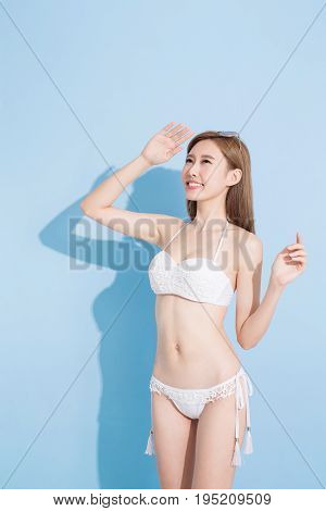 woman look somewhere and smile happily on the blue background