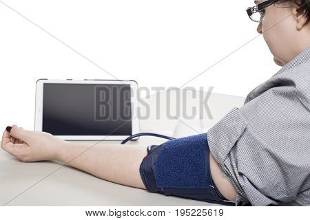 Electronic smart blood pressure monitor or sphygmomanometer with a phone or tablet hooked up to an inflatable arm cuff. This device is the modern version of the traditional medical instrument for health care.
