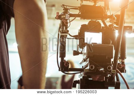 Cameraman with his video camera shooting, Adjusting Camera,film production cre. behind the scenes background.