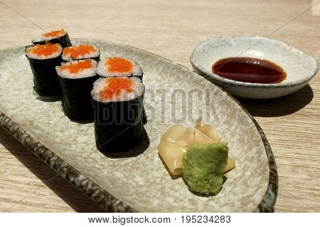 Ebiko maki sushi rolls - japanese food style in a ceramic plate.