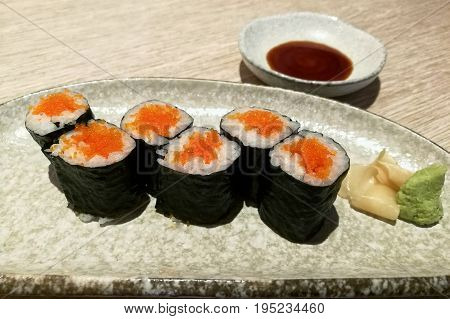 Ebiko maki sushi rolls - japanese food style in a ceramic plate.