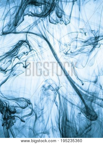 Ink swirl in a water on color background. The paint splash in the water. Soft dissemination a droplets of colored ink in water close-up. Abstract background. Explosion of color splashes acrylic ink.