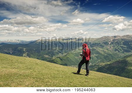 Adventurer Man With A Map  Is Walking In The Mountains