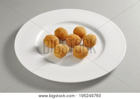 Round dish with fried breaded olives ascolane isolated on grey background